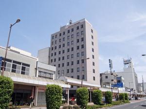ein hohes weißes Gebäude in einer Stadtstraße in der Unterkunft Main Hotel - Vacation STAY 82549 in Miyakonojō