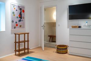 Zimmer mit einem TV und einer Tür mit einem Stuhl in der Unterkunft Strandhaus in Wyk auf Föhr