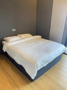 an unmade bed in a bedroom with a wooden floor at Penang Amazing SeaView Private Lift 梹城富人区绝美海景公寓私人电梯 in Tanjong Tokong