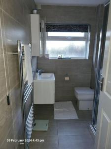 a small bathroom with a sink and a toilet at Lovely apartment with free parking & Wi-Fi in Birmingham