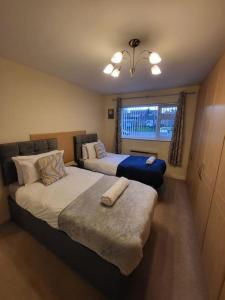 a hotel room with two beds and a window at Lovely apartment with free parking & Wi-Fi in Birmingham