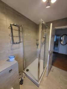 y baño con ducha y puerta de cristal. en Lovely apartment with free parking & Wi-Fi en Birmingham