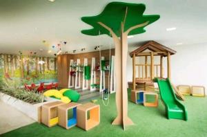 una sala de juegos para niños con un árbol y un tobogán en Loft Ilha Pura, en Río de Janeiro