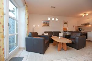 a living room with couches and a table and a kitchen at Appartementhaus "Susanne", Wohnung Seehund in Wustrow