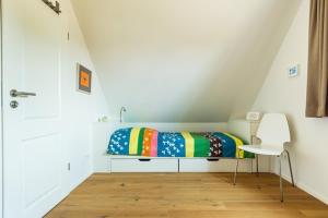 a small bedroom with a bed and a chair at Haus Wiesenweite in Born