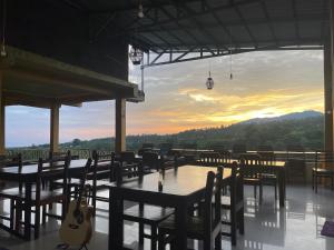 a restaurant with tables and chairs with a sunset in the background at Rinjani Golden in Senaru