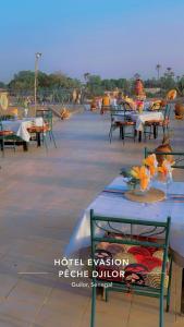 - un ensemble de tables et de chaises sur une terrasse dans l'établissement Hotel evasion peche, à Fimela