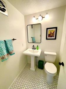 a bathroom with a white toilet and a sink at 6BR Spacious-Bright-Modern in Eugene