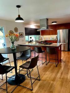 eine Küche mit einem Tisch, Stühlen und einer Theke in der Unterkunft 6BR Spacious-Bright-Modern in Eugene