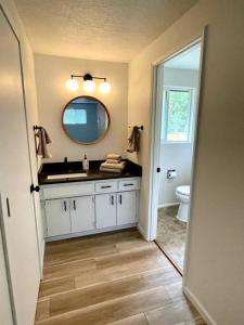 ein Bad mit einem Waschbecken und einem Spiegel in der Unterkunft 6BR Spacious-Bright-Modern in Eugene