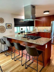 a kitchen with a island with bar stools at 6BR Spacious-Bright-Modern in Eugene