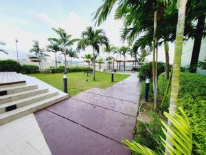 a walkway in a park with palm trees at Joyce Condo @ Centrio Towers in Cagayan de Oro
