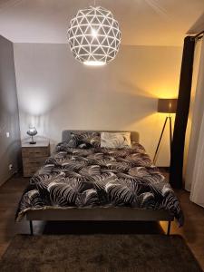 um quarto com uma cama e uma luz pendente em Résidence d'Angelo em Huy