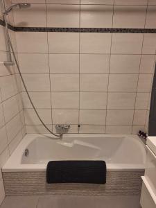 uma banheira na casa de banho com azulejos brancos em Résidence d'Angelo em Huy