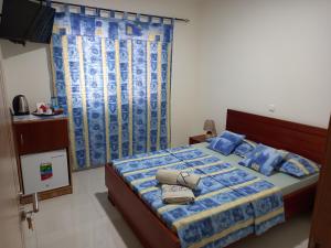 Schlafzimmer mit einem Bett mit blauer Bettwäsche und Kissen in der Unterkunft Nifa House in Espargos