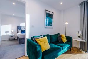 a living room with a green couch and a bedroom at Remarkable 2-Bed Apartment in Birmingham in Birmingham