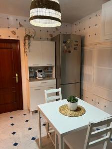 een keuken met een tafel en stoelen en een koelkast bij Apartamento Yeyé en Asturias in Corigos