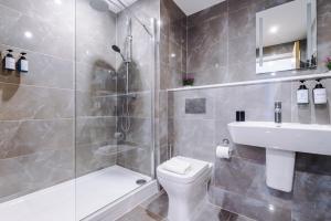 a bathroom with a shower and a toilet and a sink at Remarkable 2-Bed Apartment in Birmingham in Birmingham