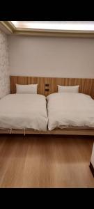 two twin beds in a room with a wooden bed frame at GAWA Hotel in Taipei
