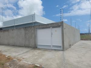 un garaje con dos puertas blancas en un edificio de hormigón en Lugar tranquilo e aconchegante, en Tibau do Sul