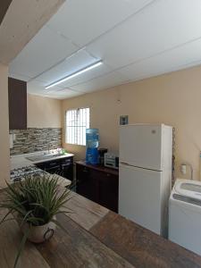 a kitchen with a white refrigerator and a sink at Casa de paso independiente para descansar por viaje in Coatzacoalcos +16 photos