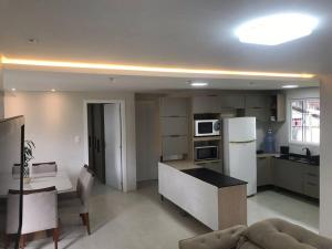 a kitchen with a white refrigerator and a table at Casa Completa com 2 Quartos no Centro in Pomerode