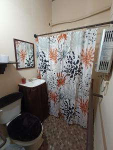 een badkamer met een douchegordijn, een toilet en een wastafel bij Excelente casa para descansar in Coatzacoalcos