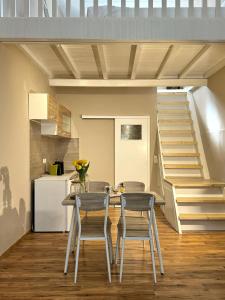 a kitchen with a table and two chairs and a staircase at Opṓra in Ermoupoli +15 photos