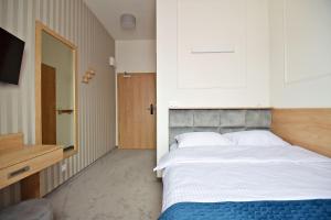 um quarto com uma cama grande e uma televisão em IVY Healthy Stay em Konstancin-Jeziorna