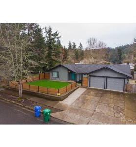 a house with a yard with a driveway and a house at Fun Festive House to Gather in Eugene