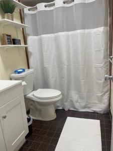 a bathroom with a white shower curtain and a toilet at “2-Bed- 1.5 Bath with outdoor bar in West Palm Beach +18 photos