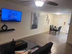 a living room with a couch and a tv on the wall at “2-Bed- 1.5 Bath with outdoor bar in West Palm Beach