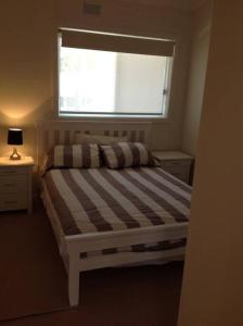 a small bedroom with a bed with a window at Waterfront Accomodation with Jetty, Port Stephens in Lemon Tree Passage