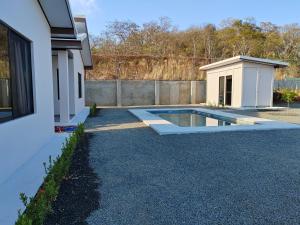 una piscina en un patio junto a una casa en Villas Brisas de Soley, en La Cruz