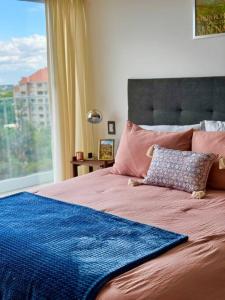 a bedroom with a large bed with a window at Departamento Elegante en Torre Leloir in Villa Marini