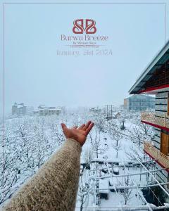 a person with their hand up in the snow at Burwa Breeze By Winsum Stays in Palchān