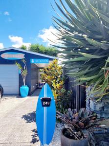 a blue surfboard sitting in front of a garage at Southpacific Motel in Whangamata