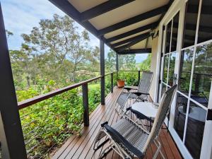 eine Veranda mit zwei Stühlen und einem Tisch darauf in der Unterkunft Hidden Valley Private Guest Suite with Views in South Grafton