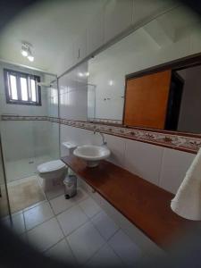 a bathroom with a toilet and a sink and a mirror at Apartamento pé na areia 5 pessoas (Beto Carrero). in Penha