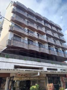 um edifício de apartamentos alto com muitas janelas em Apartamento bem localizado em Cabo Frio