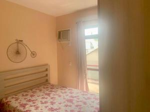 um quarto com uma cama e uma janela em Apartamento bem localizado em Cabo Frio