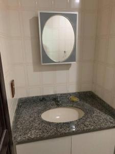 uma casa de banho com um lavatório e um espelho em Apartamento bem localizado em Cabo Frio