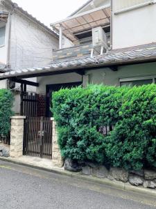 a large green bush in front of a house at ヴィラ 奈良 with gift 小さなギフト付 奈良駅から15から20分 in Nara