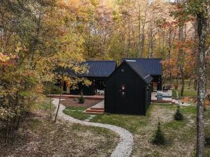 una casa negra en medio de un bosque en Villa Creek, en Logan