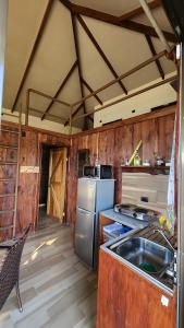 a kitchen with a refrigerator and a sink in it at Cabañas Vista de Oro in Paraíso