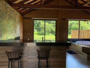 a kitchen with two chairs and a counter with a tub at Chalés Estância Campestre in Capitólio