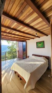 sypialnia z dużym łóżkiem i balkonem w obiekcie Cabañas Vista de Oro w mieście Paraíso
