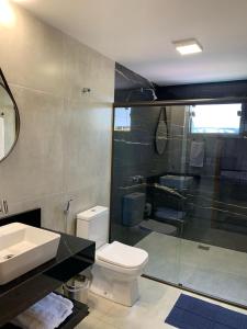 a bathroom with a shower and a toilet and a sink at Chalés Estância Campestre in Capitólio