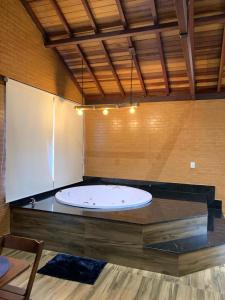 a large bath tub sitting on top of a counter at Chalés Estância Campestre in Capitólio