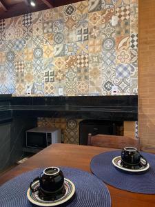 two bowls on a table with a tile wall at Chalés Estância Campestre in Capitólio